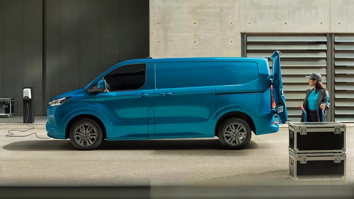 Egy kék Ford E-Transit Custom elektromos áruszállító töltés közben.