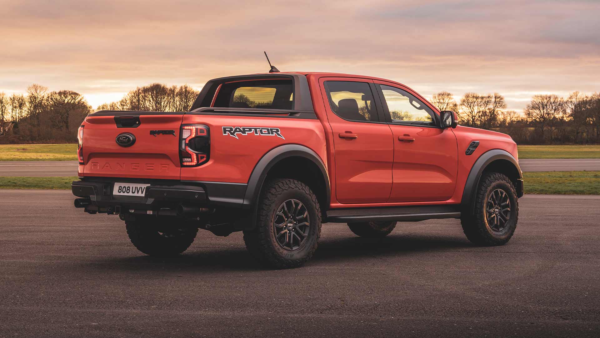 Egy úton parkoló Code Orange színű Ford Ranger Raptor hátulnézetből.