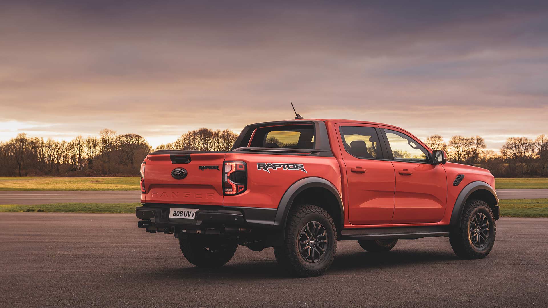 Egy úton haladó Code Orange színű Ford Ranger Raptor hátulnézetből.