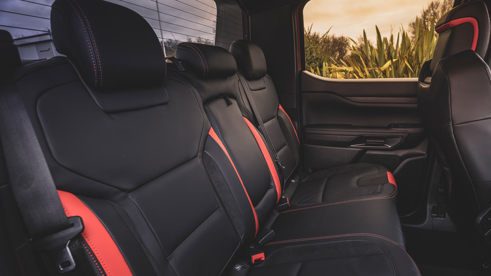 Egy Ford Ranger Raptor fekete hátsó ülései piros részletekkel.