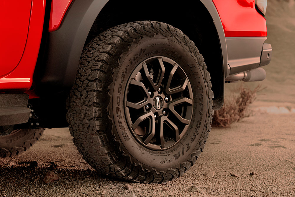 Egy Code Orange színű Ford Ranger Raptor gumiabroncsának és kerekének részlete.