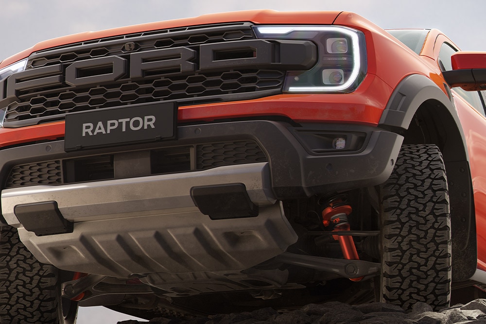 Egy Code Orange színű Ford Ranger Raptor felfüggesztésének és első hűtőrácsának első alsó nézete.