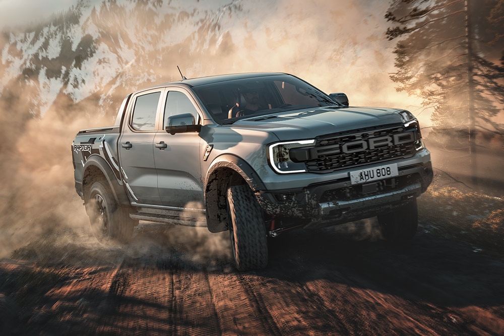 Egy Ford Ranger Raptor egy földúton halad, a háttérben hegyvidéki tájjal.