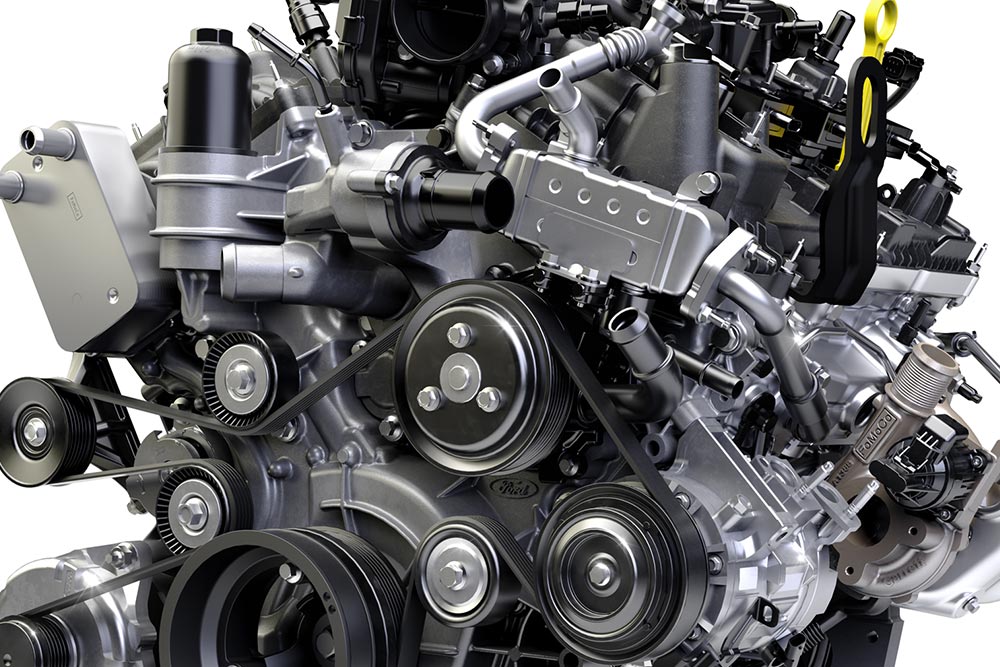 Közelképen látunk egy járműmotort ékszíjjal, ékszíjtárcsával és mechanikus alkotóelemekkel.