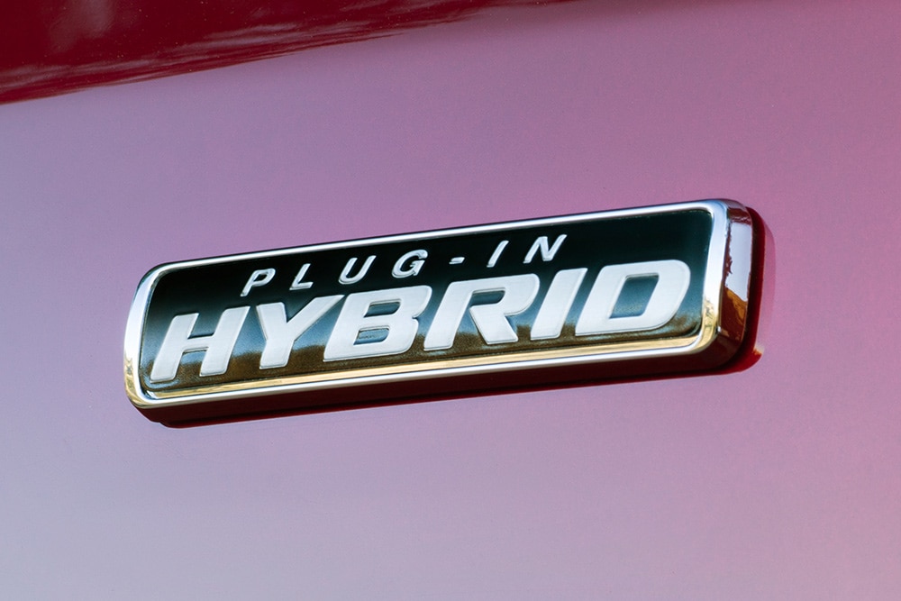 „Plug-in Hybrid” jelvény egy piros Ford Transit Custom karosszériáján.