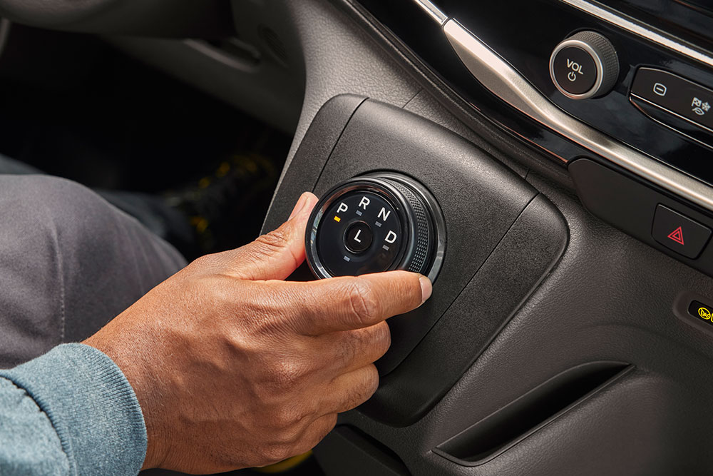 Közelkép egy kézről, amint elforgatja a sebességváltó tárcsát egy Ford E-Transit elektromos áruszállítóban.