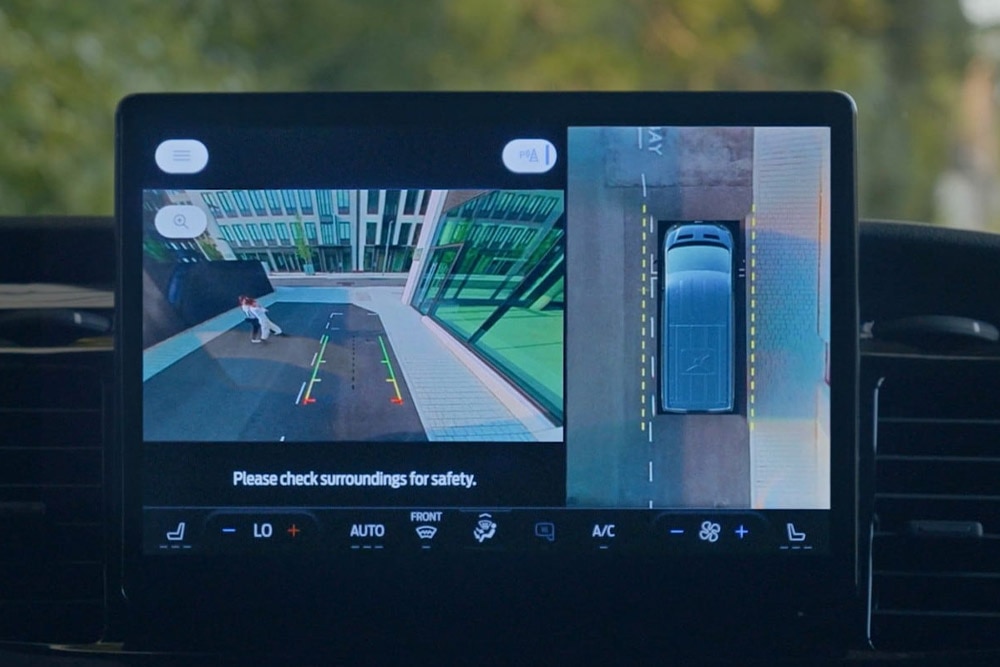 A műszerfali képernyő egy Ford Transit áruszállító felülnézeti képét mutatja egy gyalogossal együtt.