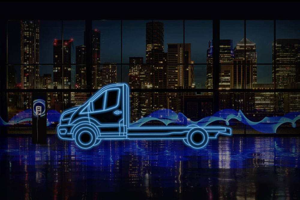 Egy Ford E-Transit vezetőfülkés alváz és töltőállomás neonkék körvonala a város látképe előtt.
