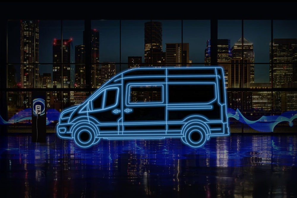 Egy Ford E-Transit duplakabinos áruszállító és töltőállomás neonkék körvonala a város látképe előtt.