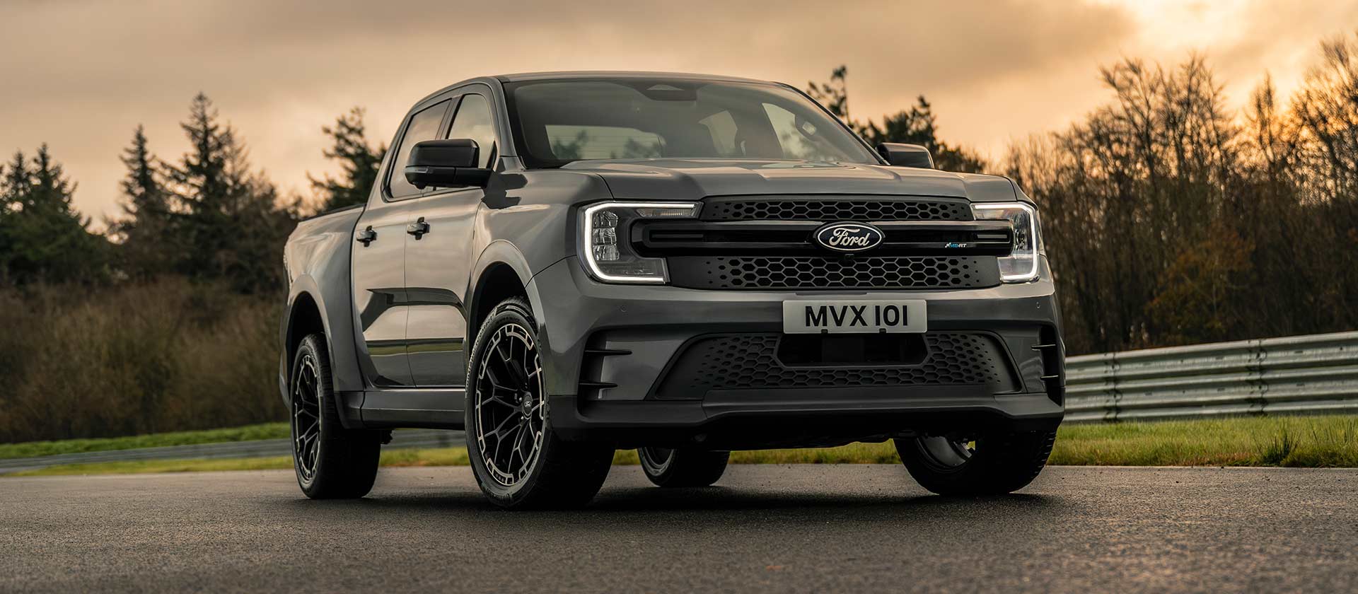 Egy fehér Ford Ranger MS-RT modellt látunk félig elöl-, félig oldalnézetből a naplementében.
