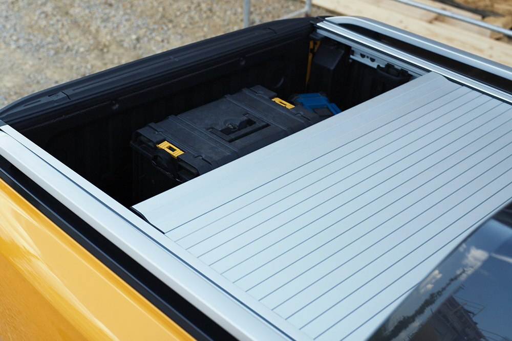 Egy munkást látunk, aki a Ford Ranger beépített oldallépcsőjére lép.