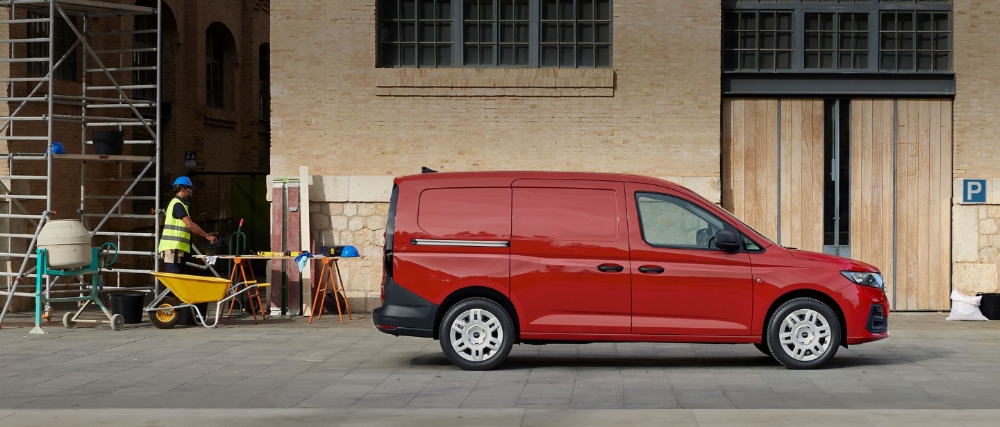 A vadonatúj, Maple Red színű Ford Transit Connect egy építkezésen parkol, az oldalsó rakodóajtaját látjuk.