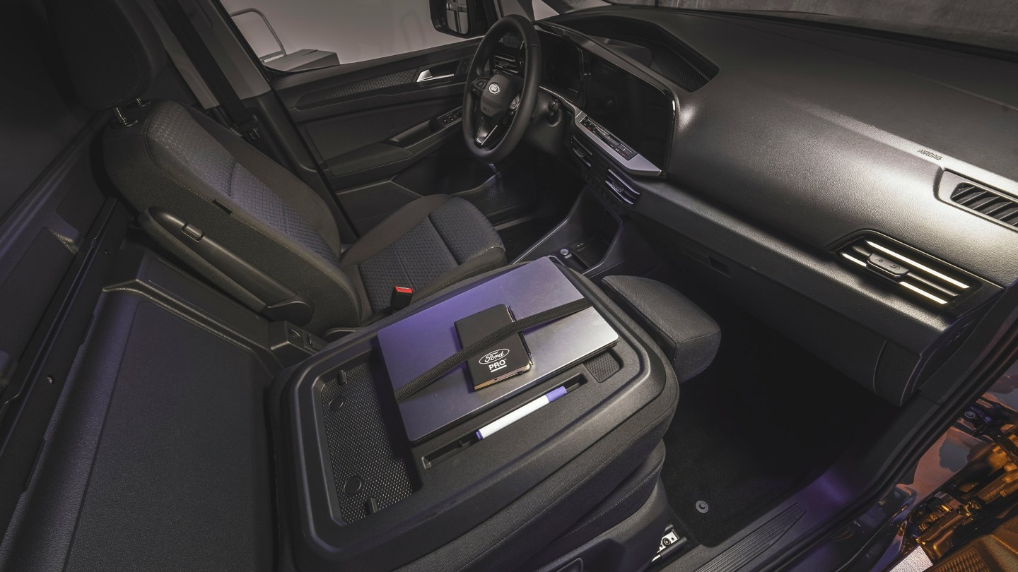 Egy laptop és egy Ford Pro jegyzettömb a vadonatúj Ford Transit Connect munkaasztalán.