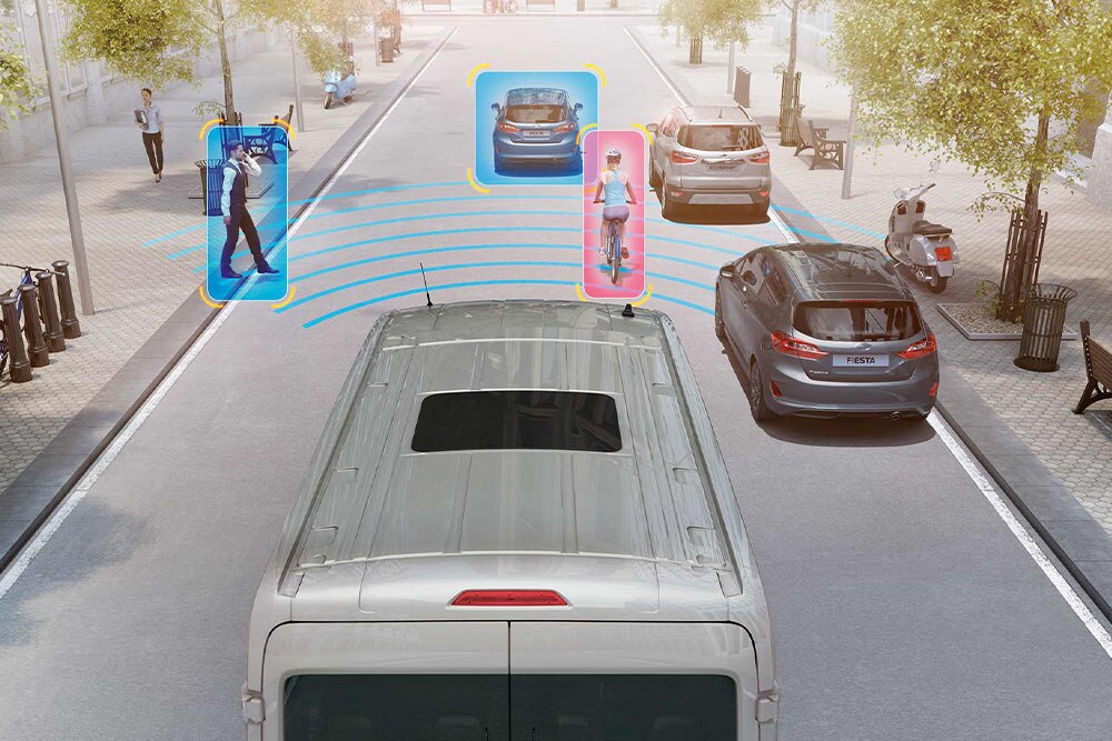 Egy Ford Transit Van fejlett biztonsági funkciókkal, amelyek észlelik a gyalogosokat és a járműveket.