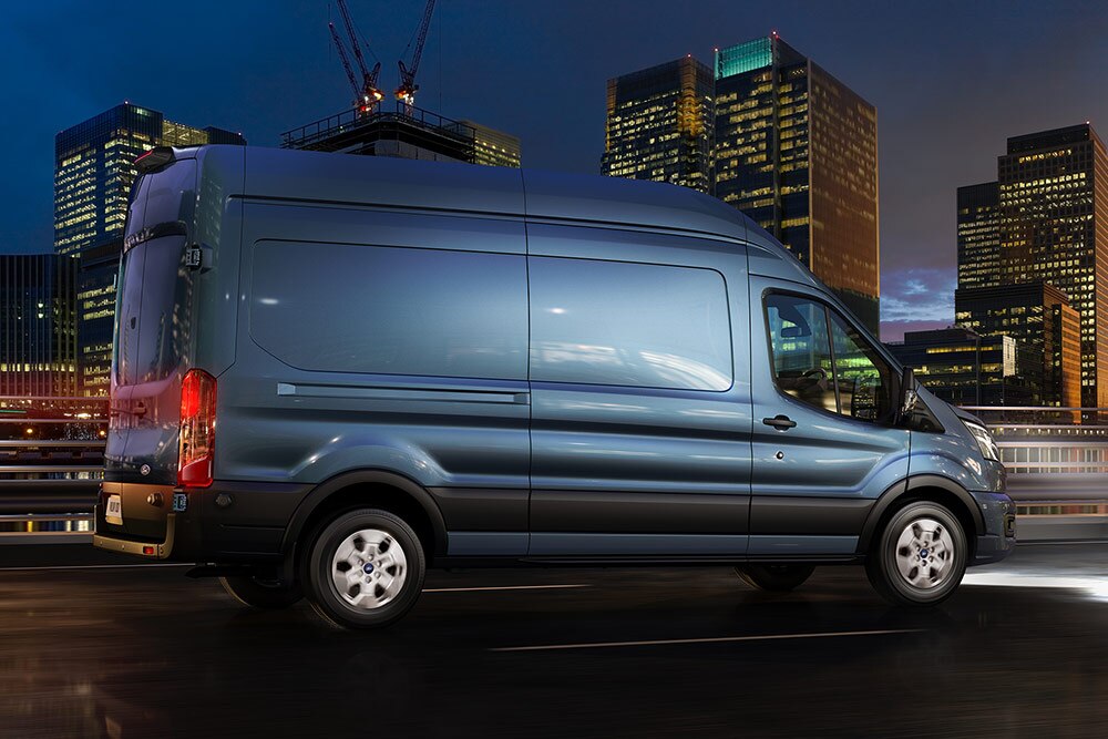 Egy Ford Transit Van egy városban halad az úton éjszaka.