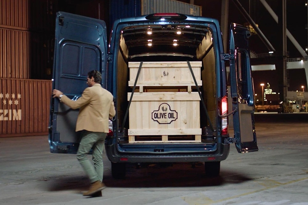 Egy Ford Transit Van nyitott hátsó ajtókkal és benne elhelyezett rakománnyal.