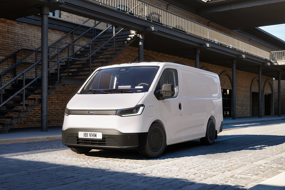 Fehér Ford Transit City® L1H1 áruszállító parkol egy téglaépület előtt.