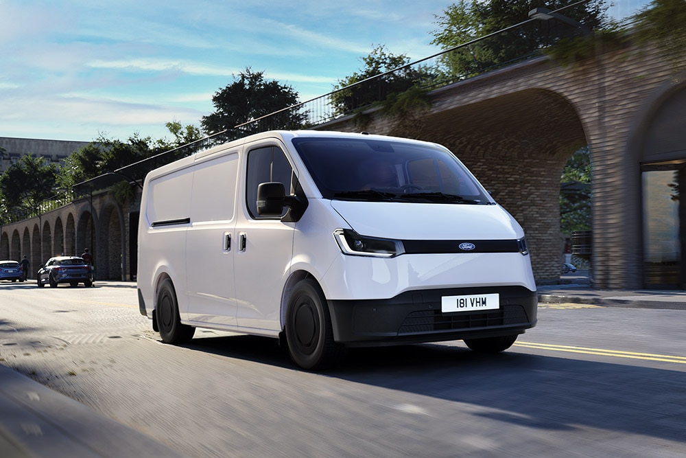 Fehér Ford Transit City® L1H1 áruszállító egy városban halad az úton.