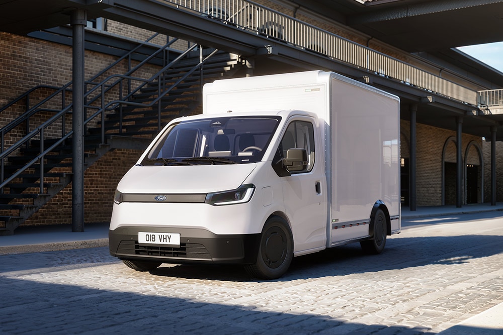 Fehér Ford Transit City® Chassis Cab áruszállító parkol egy téglaépület előtt.