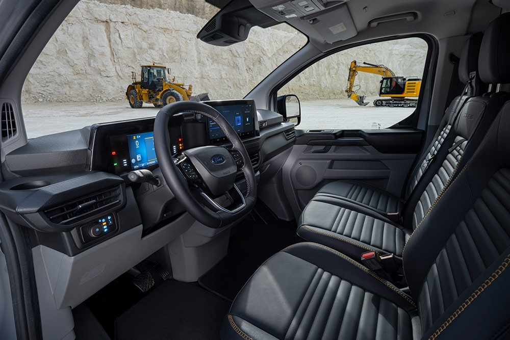 Egy Ford Transit Custom áruszállító utasterében a műszerfalat, a kormánykereket és az üléseket látjuk.