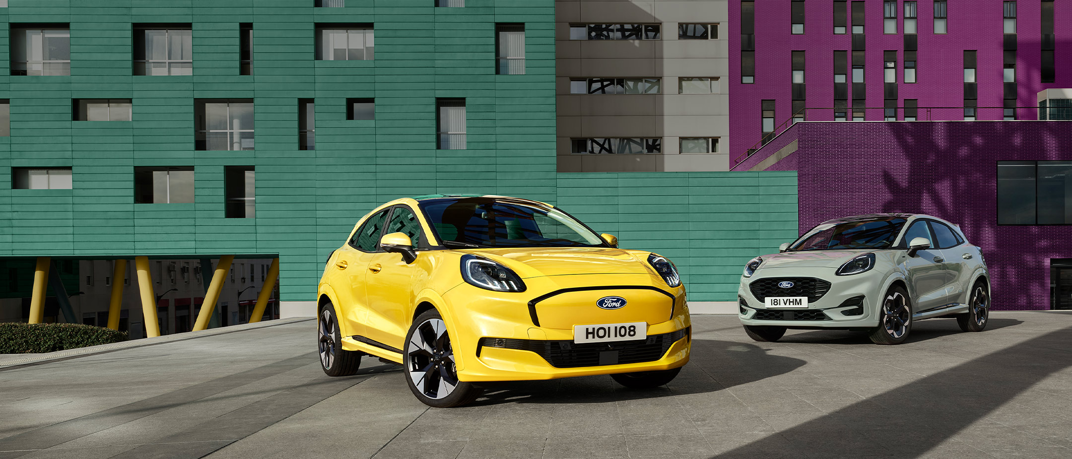Egy sárga, elektromos Ford Puma Gen-E® és egy szürke, EcoBoost® benzinmotoros Ford Puma® áll egymás mellett. 